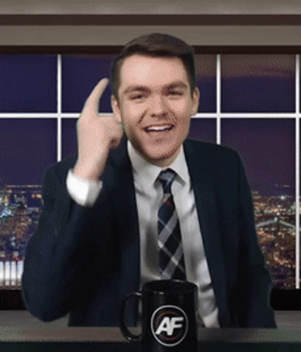 A Man In A Suit And Tie Is Giving A Thumbs Up Next To A Mug That Says Af GIF