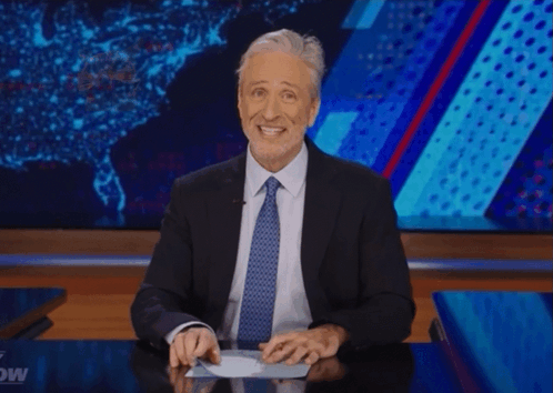 A Man In A Suit And Tie Is Giving A Thumbs Up Sign GIF