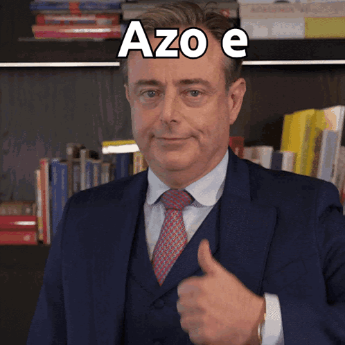 A Man In A Suit And Tie Is Giving A Thumbs Up With Azo E Written Above Him GIF
