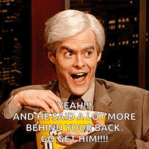 A Man In A Suit And Tie Is Holding A Bag Of M & M 'S Chips GIF