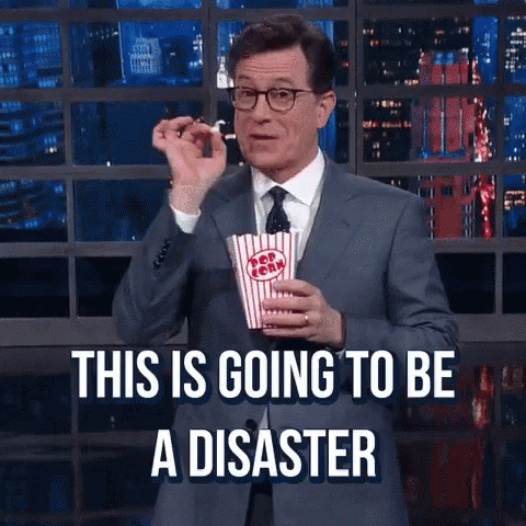 A Man In A Suit And Tie Is Holding A Bag Of Popcorn And Says This Is Going To Be A Disaster GIF