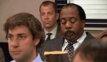 A Man In A Suit And Tie Is Holding A Book That Says Bible GIF