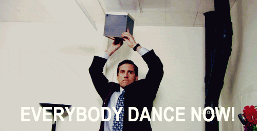 A Man In A Suit And Tie Is Holding A Box Over His Head With The Words " Everybody Dance Now " Above Him GIF
