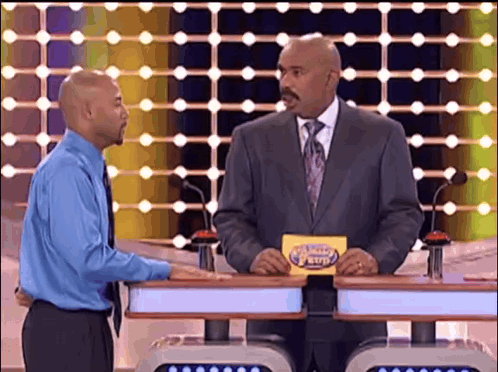 A Man In A Suit And Tie Is Holding A Card That Says ' The Price Is Right ' On It GIF
