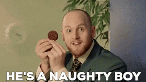 Man In Suit Holding Cookie Says Naughty Boy GIF