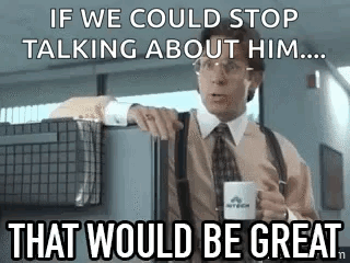 A Man In A Suit And Tie Is Holding A Cup Of Coffee And Talking To Someone . GIF