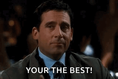A Man In A Suit And Tie Is Holding A Drink And Pointing At The Camera With The Words `` Your The Best '' . GIF