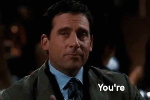 a man in a suit and tie is holding a drink in his hand and the word welcome is behind him