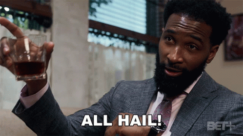A Man In A Suit And Tie Is Holding A Glass Of Whiskey And Says All Hail GIF