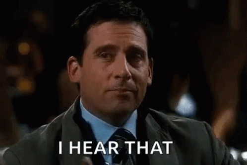 A Man In A Suit And Tie Is Holding A Glass Of Whiskey And Says `` I Hear That '' . GIF