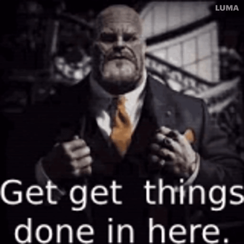 A Man In A Suit And Tie Is Holding A Gun And Says Get Things Done In Here GIF