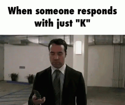 A Man In A Suit And Tie Is Holding A Gun In A Garage . GIF