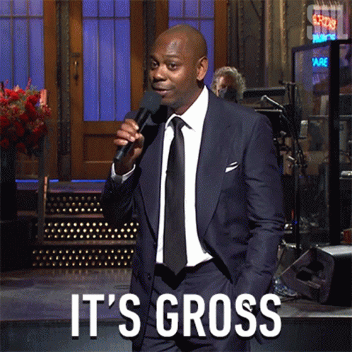 A Man In A Suit And Tie Is Holding A Microphone And Says It 'S Gross On The Bottom GIF