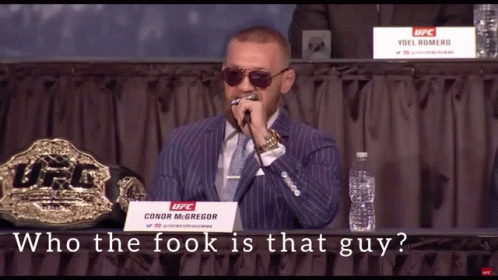 A Man In A Suit And Tie Is Holding A Microphone In Front Of A Sign That Says Ufc GIF