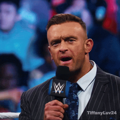 A Man In A Suit And Tie Is Holding A Microphone That Says Tiffanyluv24 GIF