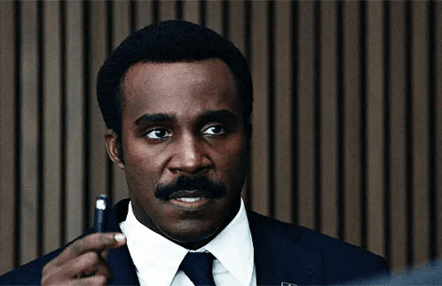 a man in a suit and tie is holding a pen