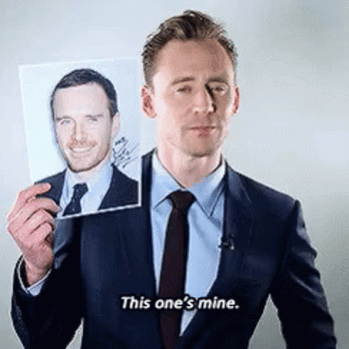 A Man In A Suit And Tie Is Holding A Picture Of Another Man And Saying This One 'S Mine . GIF