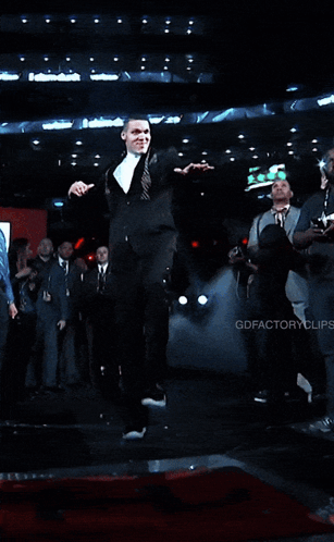 A Man In A Suit And Tie Is Holding A Piece Of Paper GIF