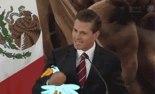 A Man In A Suit And Tie Is Holding A Stuffed Penguin In Front Of A Microphone . GIF