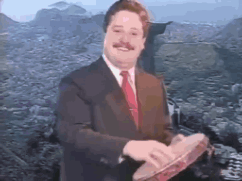 a man in a suit and tie is holding a tambourine in his hands