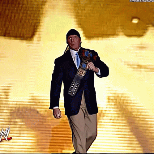 A Man In A Suit And Tie Is Holding A Wrestling Belt That Says ' Intercontinental ' On It GIF