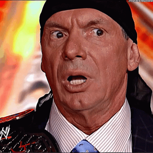A Man In A Suit And Tie Is Holding A Wrestling Trophy And Making A Surprised Face . GIF