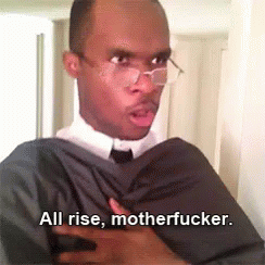 A Man In A Suit And Tie Is Holding His Chest And Says All Rise Motherfucker GIF