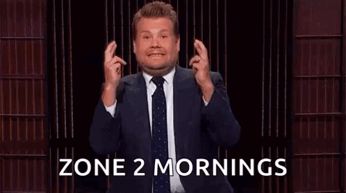 A Man In A Suit And Tie Is Holding His Fingers Crossed In Front Of A Podium . GIF