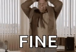 A Man In A Suit And Tie Is Holding His Head In A Room With The Word Fine . GIF