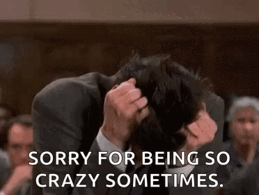 A Man In A Suit And Tie Is Holding His Head In His Hands And Says `` Sorry For Being So Crazy Sometimes . '' GIF