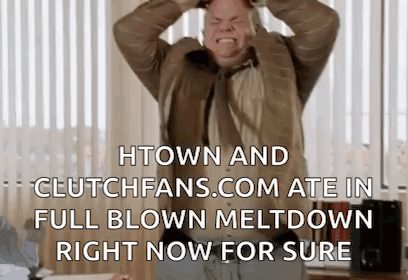 A Man In A Suit And Tie Is Holding His Head In His Hands While Standing In Front Of A Window . GIF