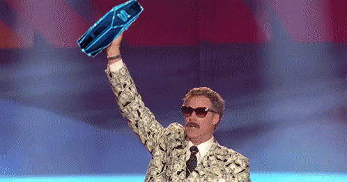 A Man In A Suit And Tie Is Holding Up A Blue Bottle That Says ' Jbl ' On It GIF