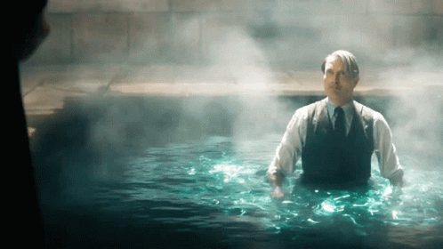 A Man In A Suit And Tie Is In A Pool Of Water GIF