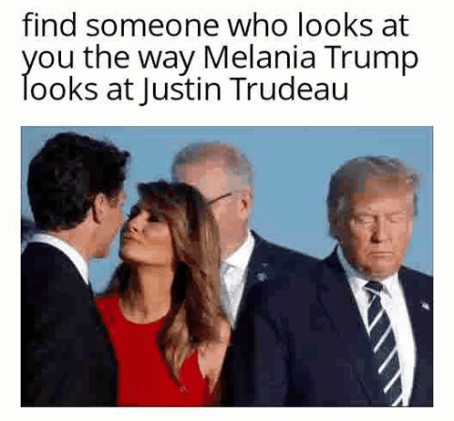 A Man In A Suit And Tie Is Kissing A Woman On The Cheek . GIF