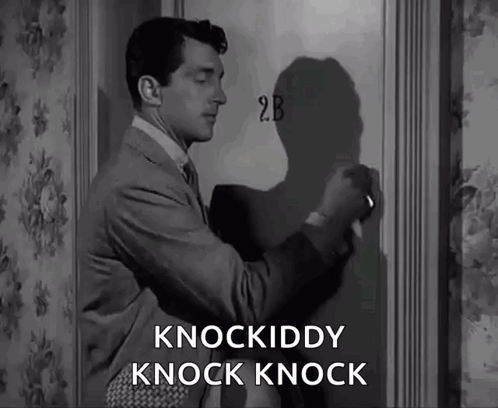 A Man In A Suit And Tie Is Knocking On A Door That Says 2B On It GIF