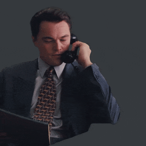 A Man In A Suit And Tie Is Laughing And Clapping His Hands GIF