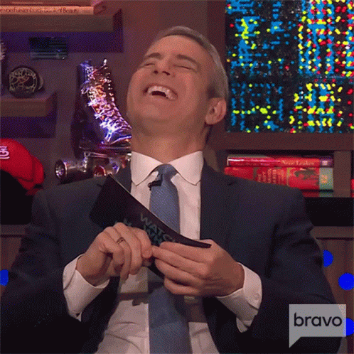 Man In Suit Laughing Holding Bravo Card GIF