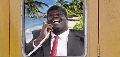 A Man In A Suit And Tie Is Laughing While Talking On The Phone GIF