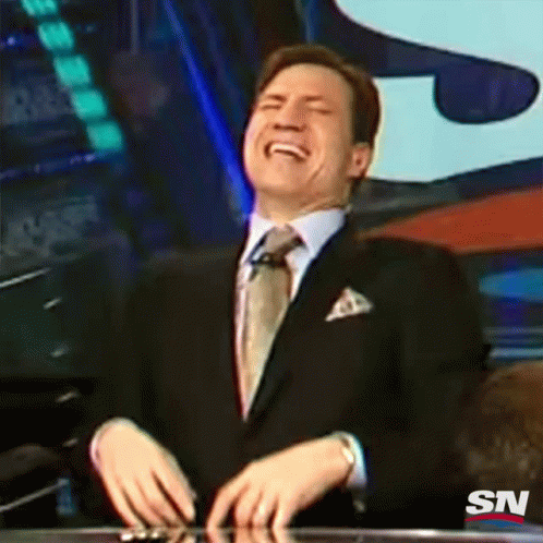 A Man In A Suit And Tie Is Laughing With A Sn Logo In The Background GIF
