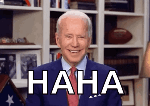 A Man In A Suit And Tie Is Laughing With The Word Haha Behind Him GIF