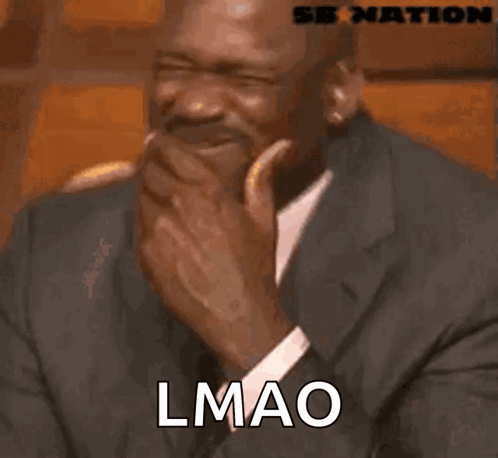 A Man In A Suit And Tie Is Laughing With The Word Lmao Written On His Face GIF