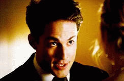 a man in a suit and tie is looking at a woman in a dress
