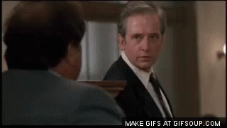 a man in a suit and tie is looking at another man in a suit and tie .
