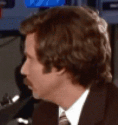 A Man In A Suit And Tie Is Looking At Something GIF