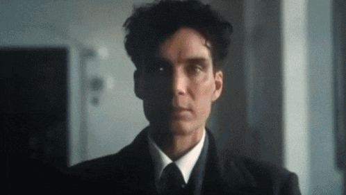 A Man In A Suit And Tie Is Looking At The Camera With A Serious Look On His Face . GIF