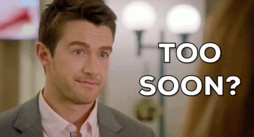 a man in a suit and tie is looking at the camera with the words too soon behind him