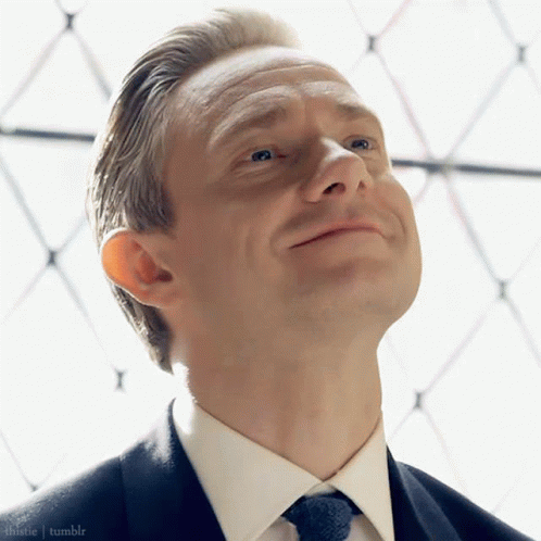 A Man In A Suit And Tie Is Looking Up At The Sky GIF