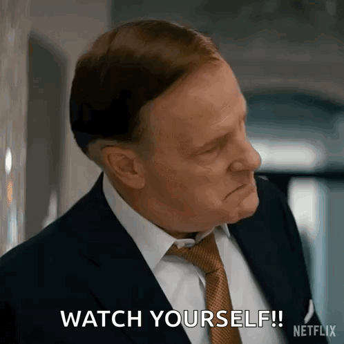 A Man In A Suit And Tie Is Making A Face And Saying `` Watch Yourself '' . GIF