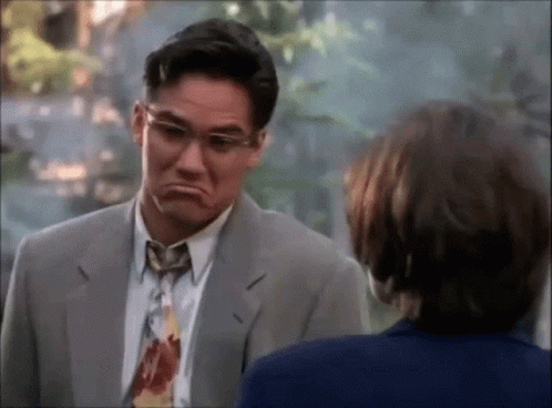 A Man In A Suit And Tie Is Making A Face GIF