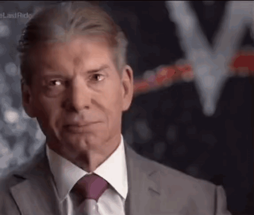 A Man In A Suit And Tie Is Making A Face . GIF